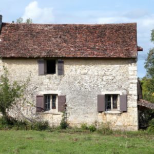 Une maison blanche au milieu d'un champ.